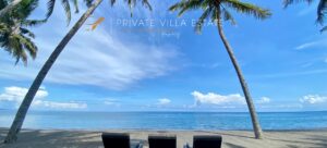 Luxury beachfront villa in Lombok by The Lombok Lodge Hospitality — private villa estate with ocean view, palm trees, and sun loungers on a serene tropical beach